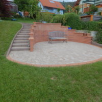 gepflasterter Gartenbereich mit Sitzbank